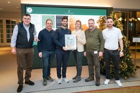 Gruppenfoto im Foyer des GC SLR mit verschiedenen Vertreter mit Präsentation der gerahmten Golf und Naturkunde, die Moritz Lampert und Cordula Humbert hält