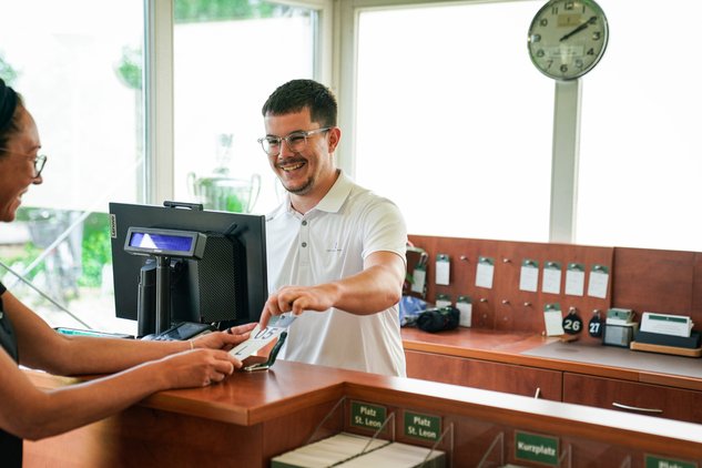 Mitarbeiter steht hinter Service Schalter - Jobs im Golfsport